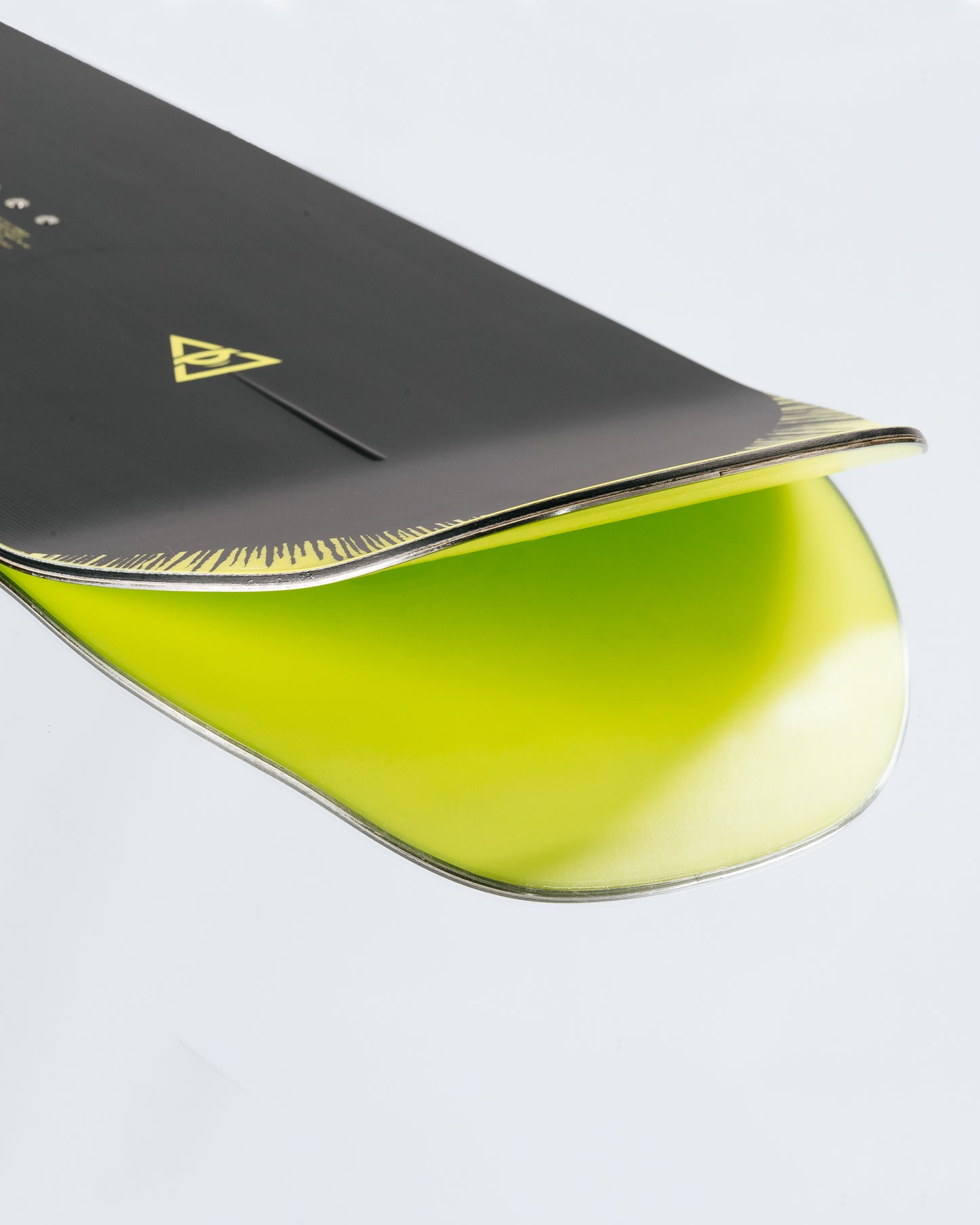 The tail and base of the freestyle snowboard with HotRods and PowerSlide base. Artifact 2025 | Rome Snowboards™ 2025.