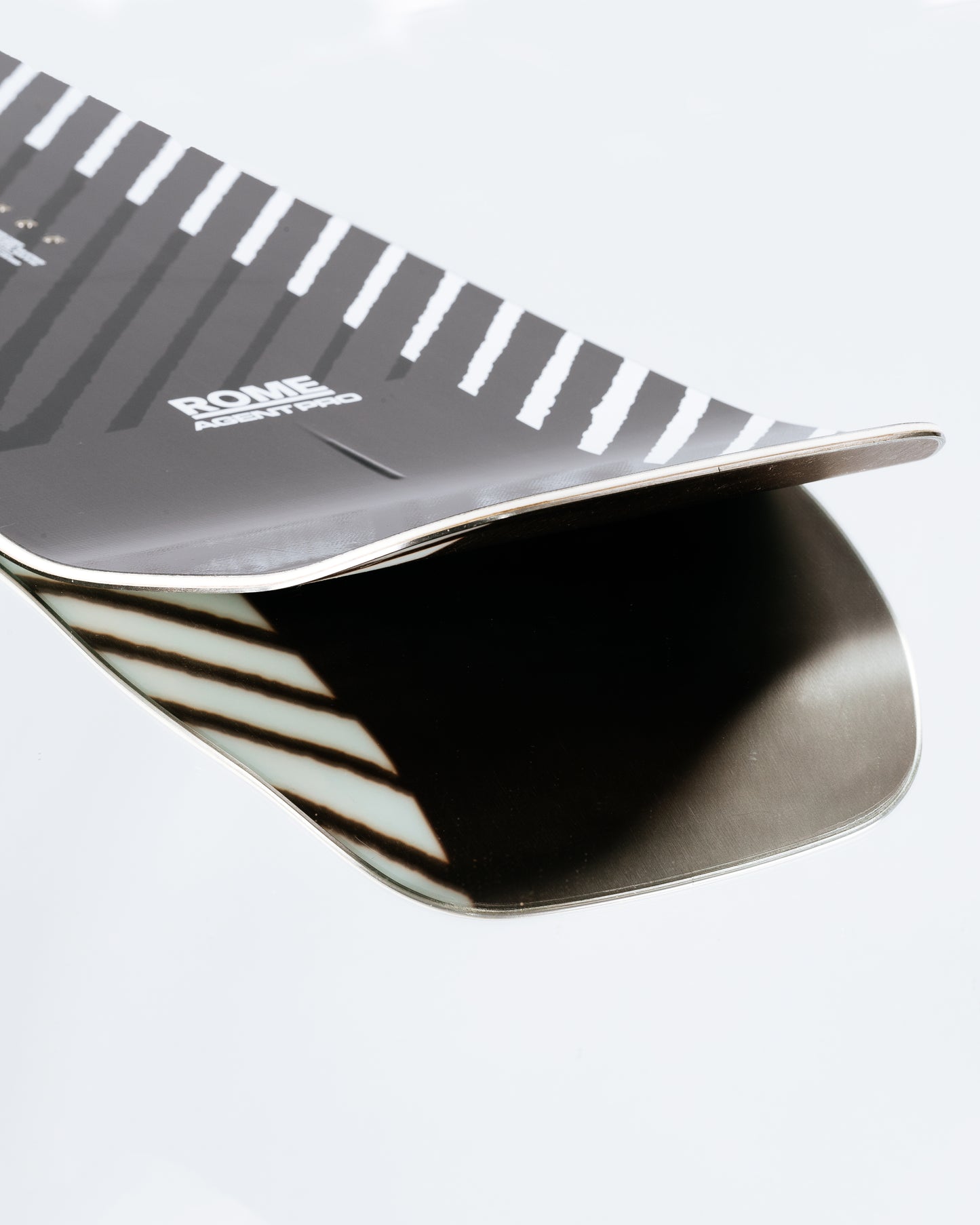 The tail and base of the freestyle snowboard with HotRods and SinterSpeed base. Agent Pro 2025 | Rome Snowboards™ 2025.